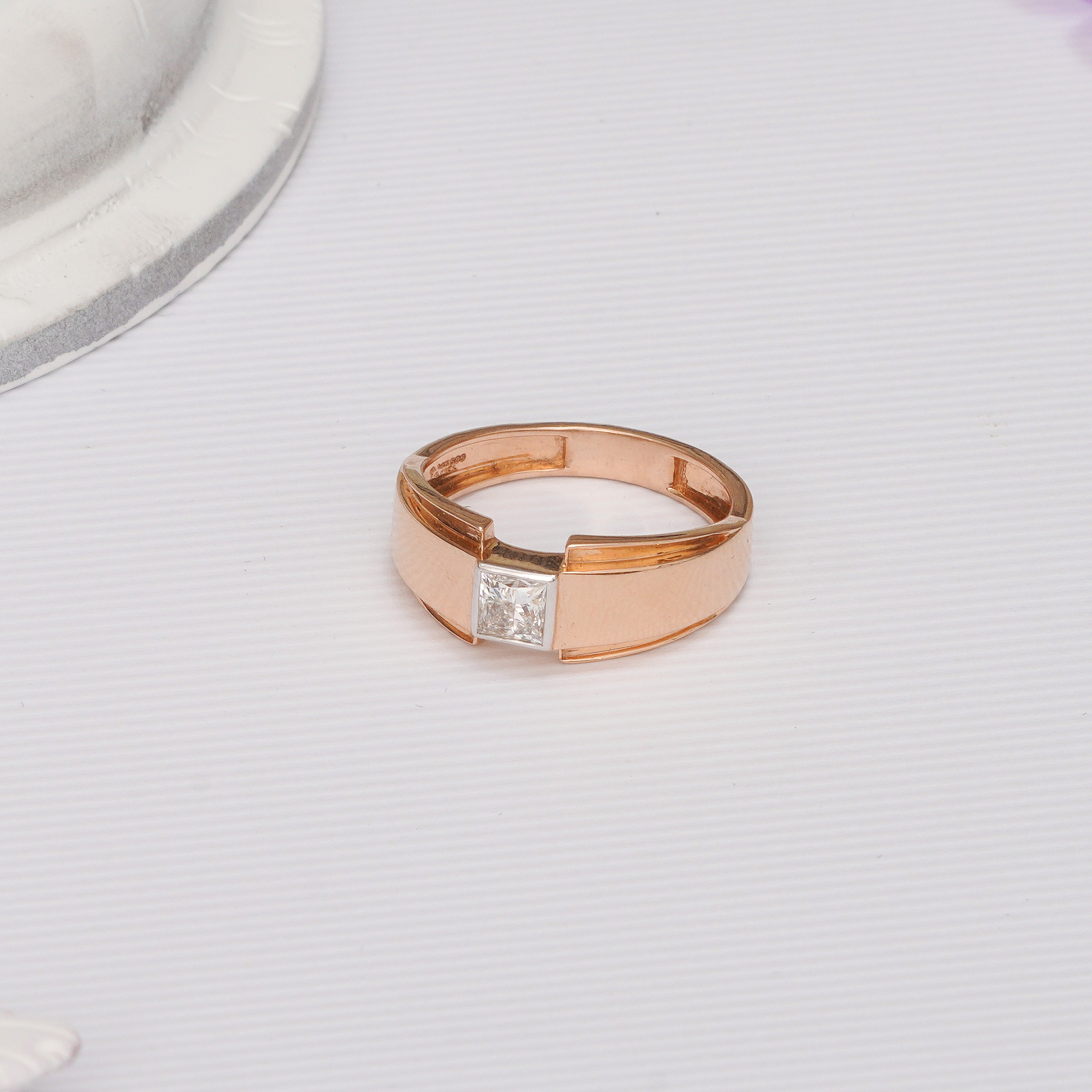 Rose gold ring with a diamond on a light gray background. Aries Men's Princess Lab Grown Diamond Band