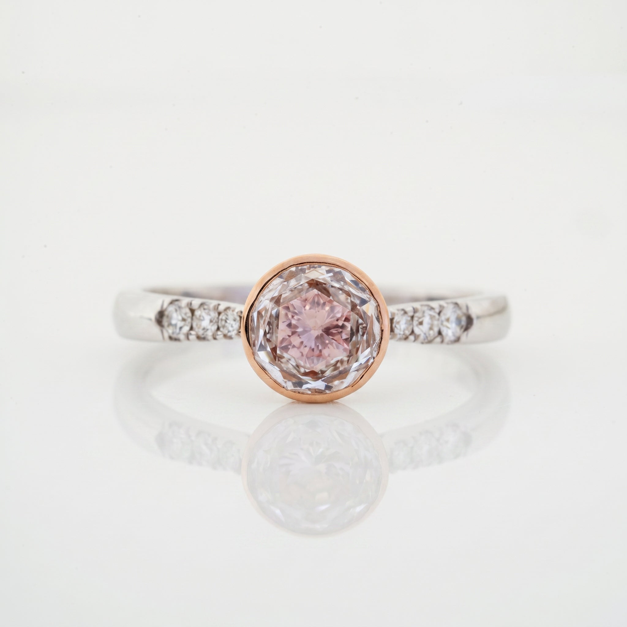 Round pink diamond aura bezel ring with diamond accent shoulders in rose and white gold by Glora Diamonds Chennai