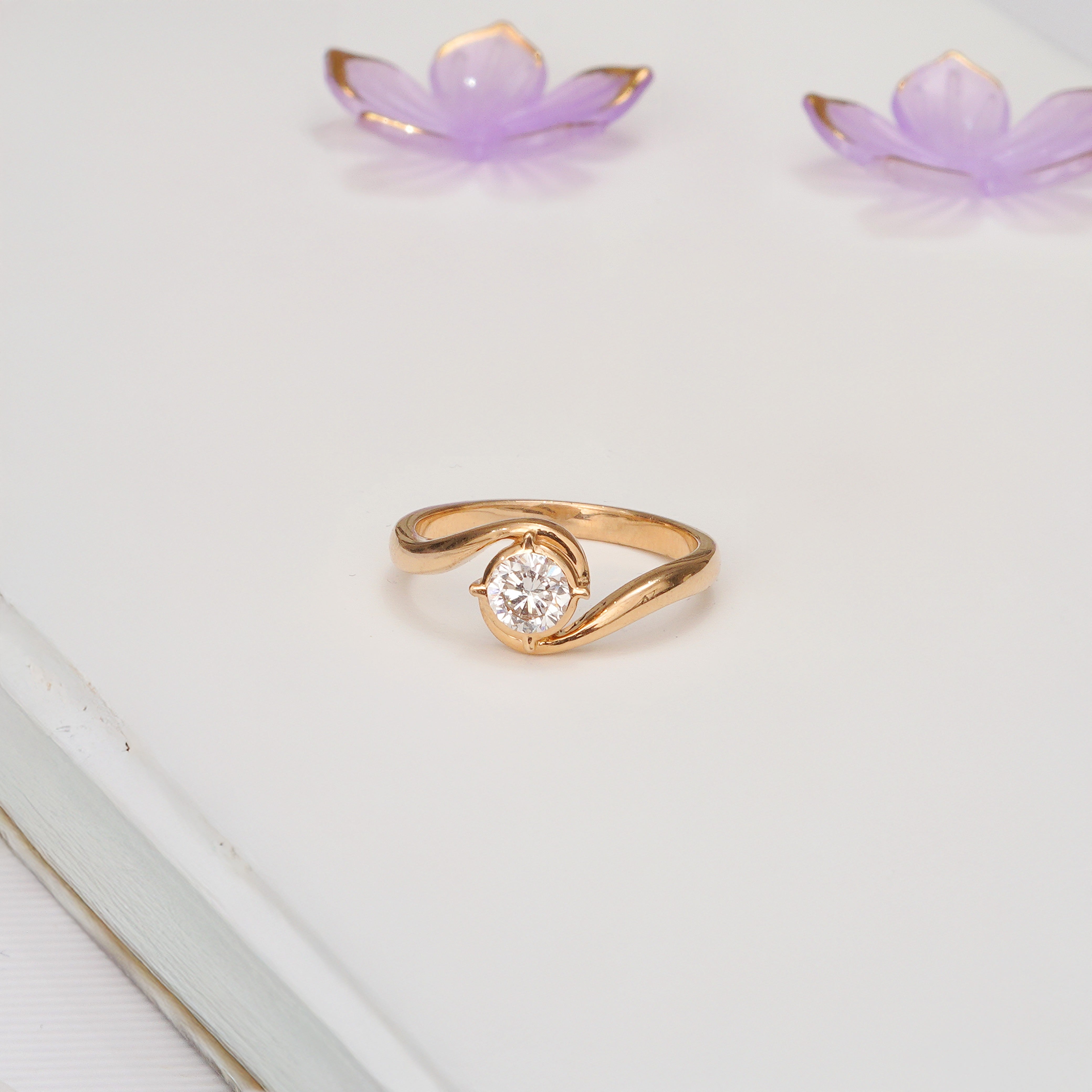 Round lab grown diamond solitaire in an 18K yellow gold bypass swirl setting