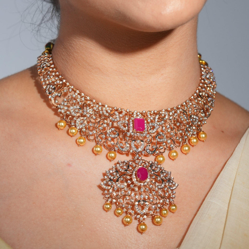 A model wearing an ornate necklace with a pink centre stone