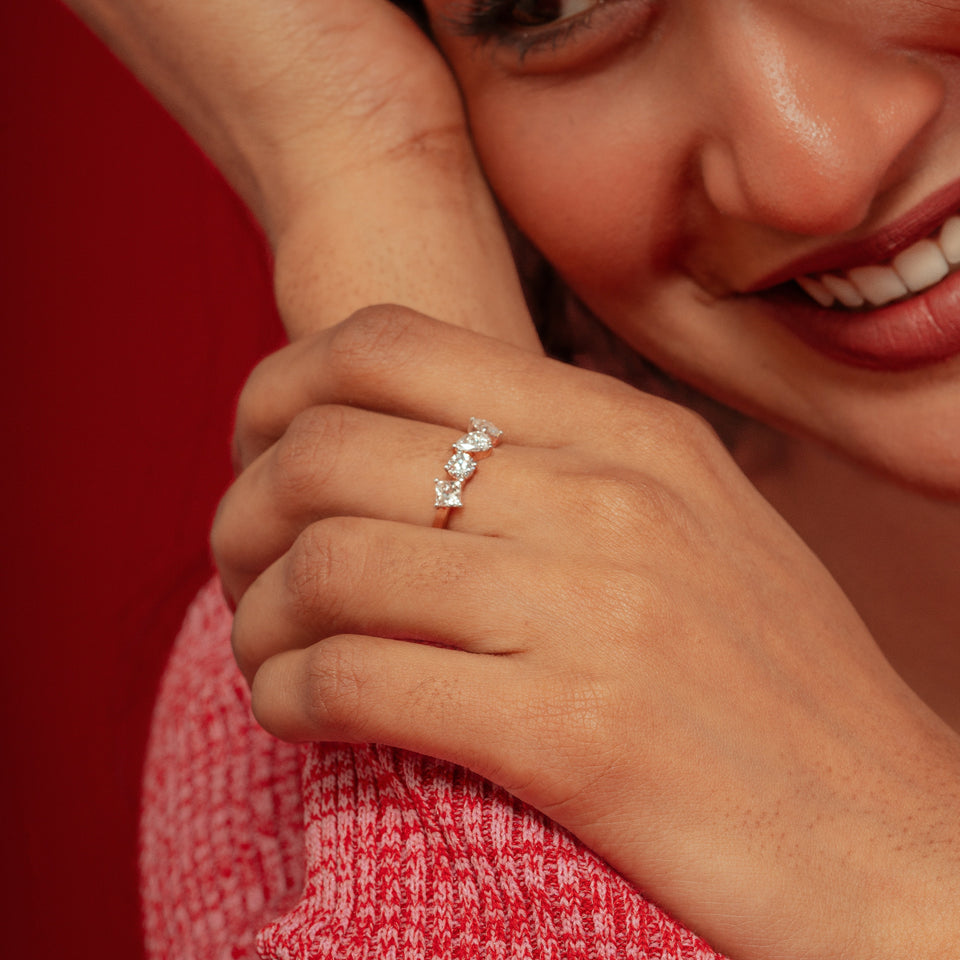 A smiling woman holding a hand with a ring near her face