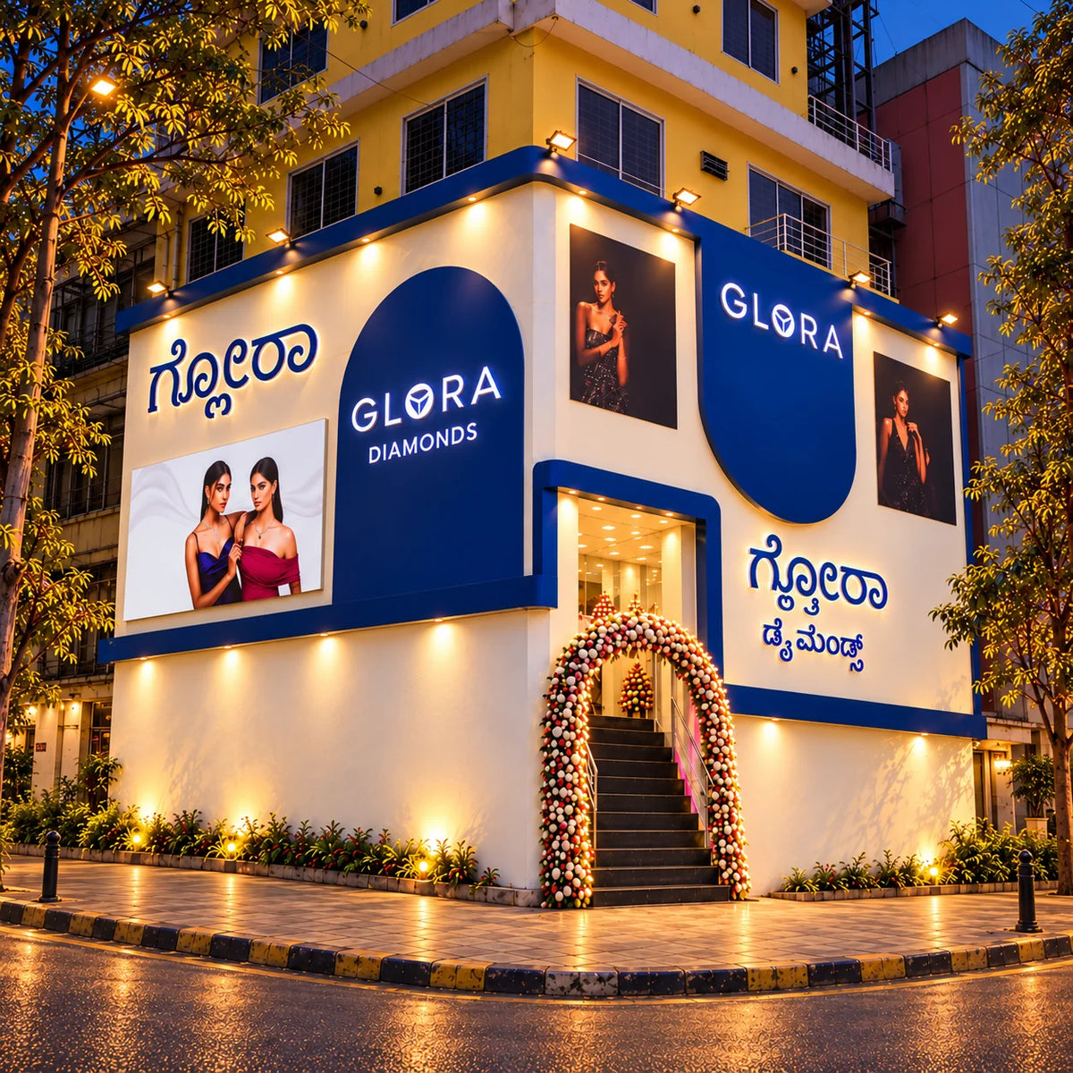Square evening exterior render of Glora Diamonds showroom on Dickenson Road, Bengaluru, showing the illuminated blue facade and entrance steps