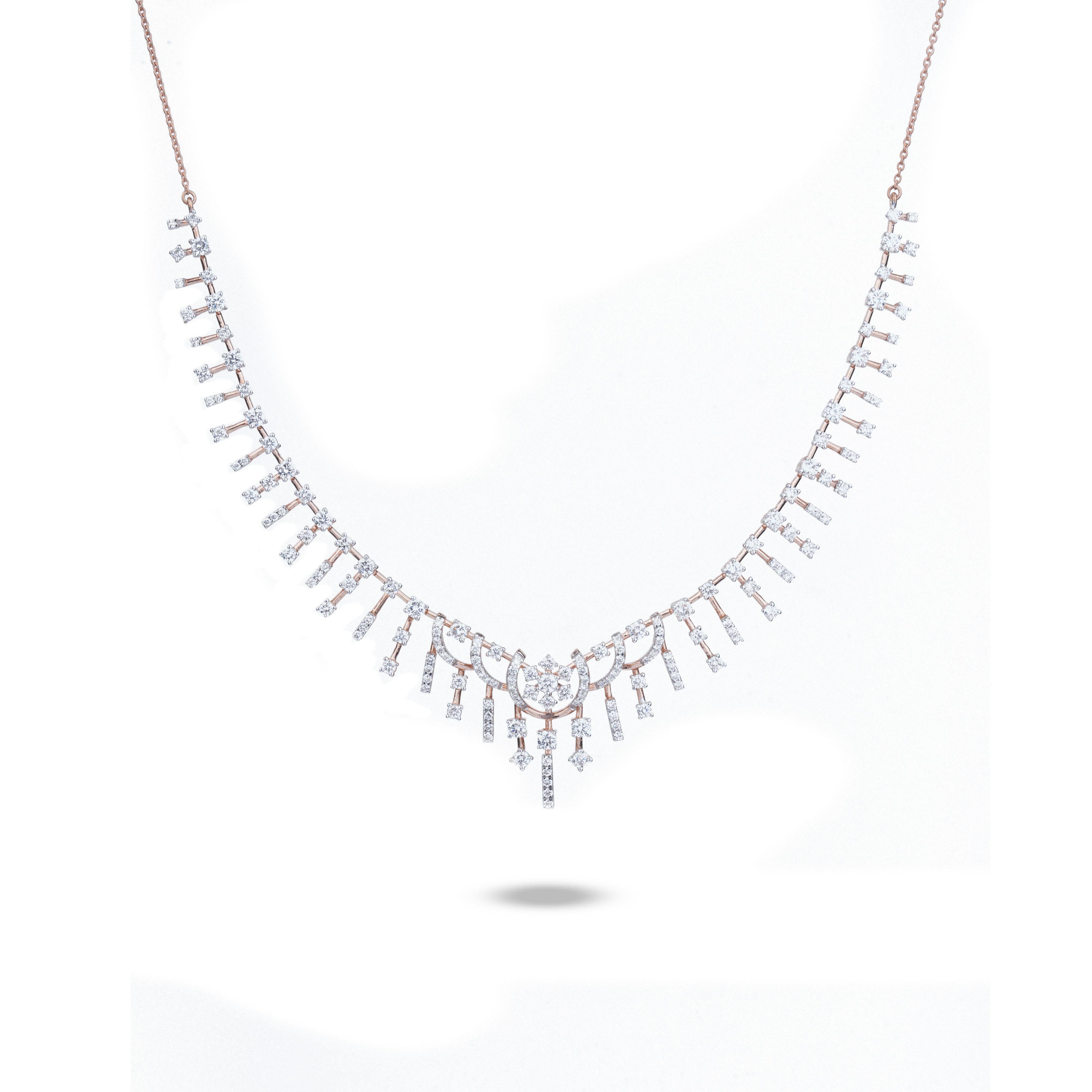 A delicate necklace with a V-shaped arrangement of small clear stones in a rose gold setting, suspended from a fine rose gold chain, shown against a plain white background.