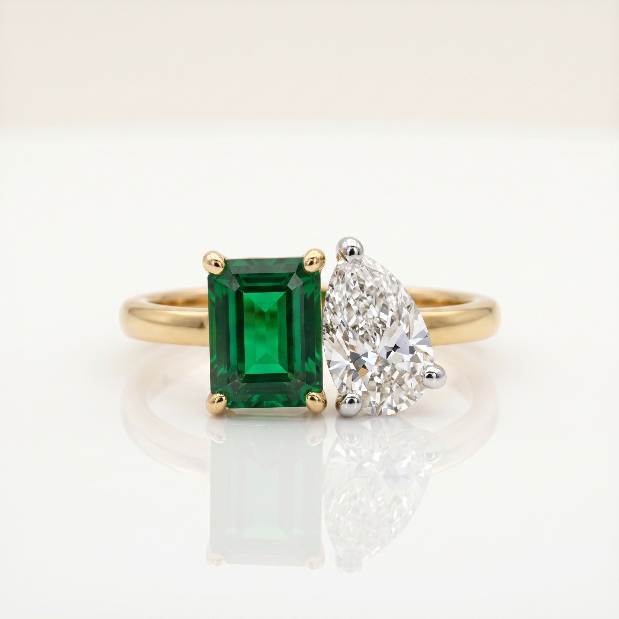 Emerald cut emerald and pear diamond Toi et Moi ring with dual-stone setting in gold by Glora Diamonds Chennai