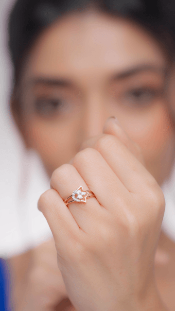 A person's hand displaying a diamond ring with a visible band and a single large diamond on it.