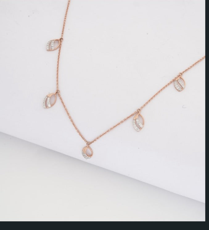Rose gold necklace with diamond-like stones on a white background