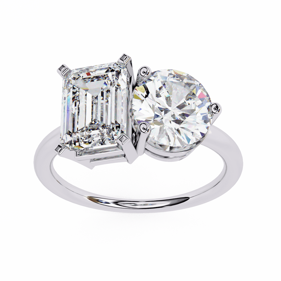 A silver-colored band diamond ring with one large round diamond and one large emerald-cut diamond side by side.