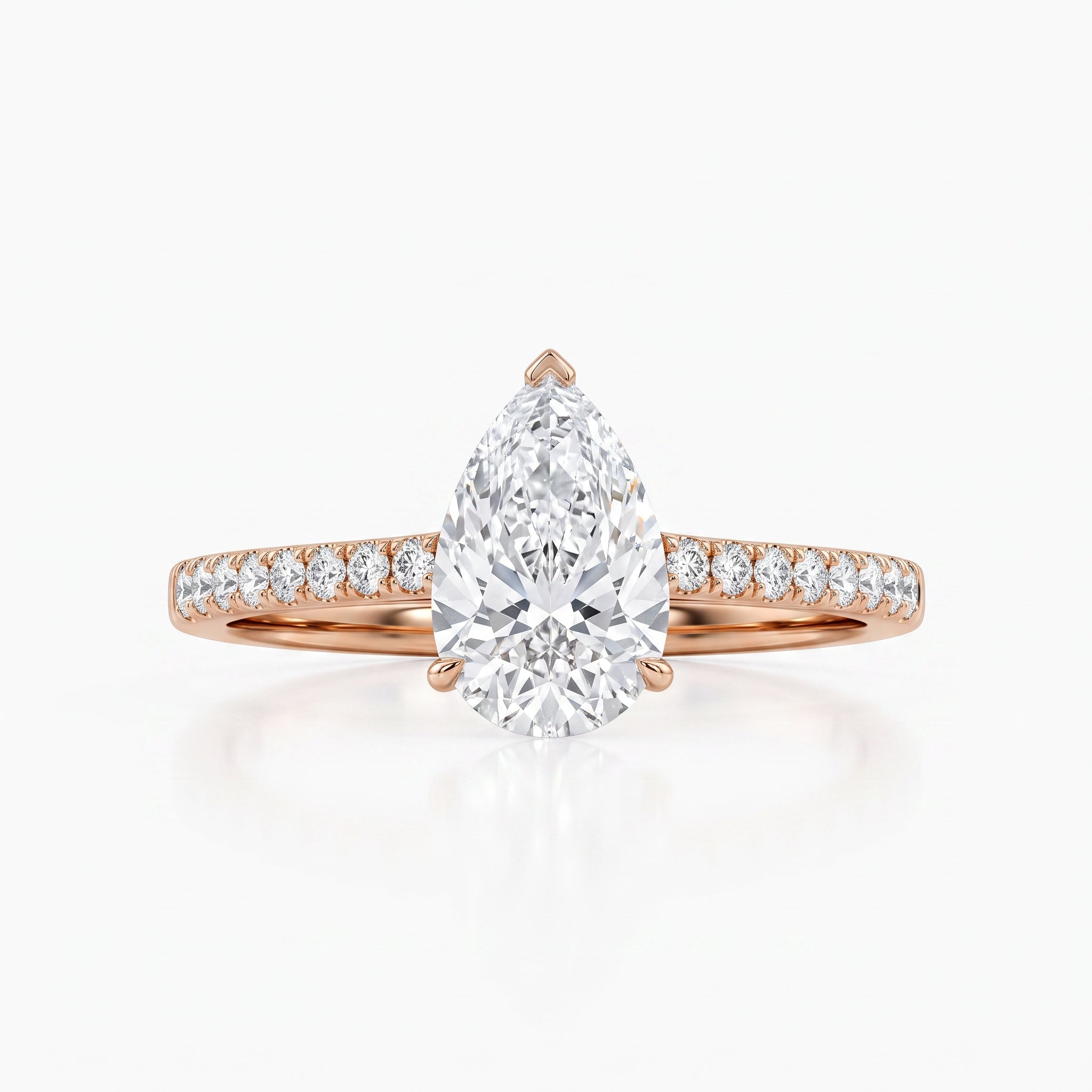 A pear-cut diamond engagement ring in rose gold with a pavé band, set against a clean white background.