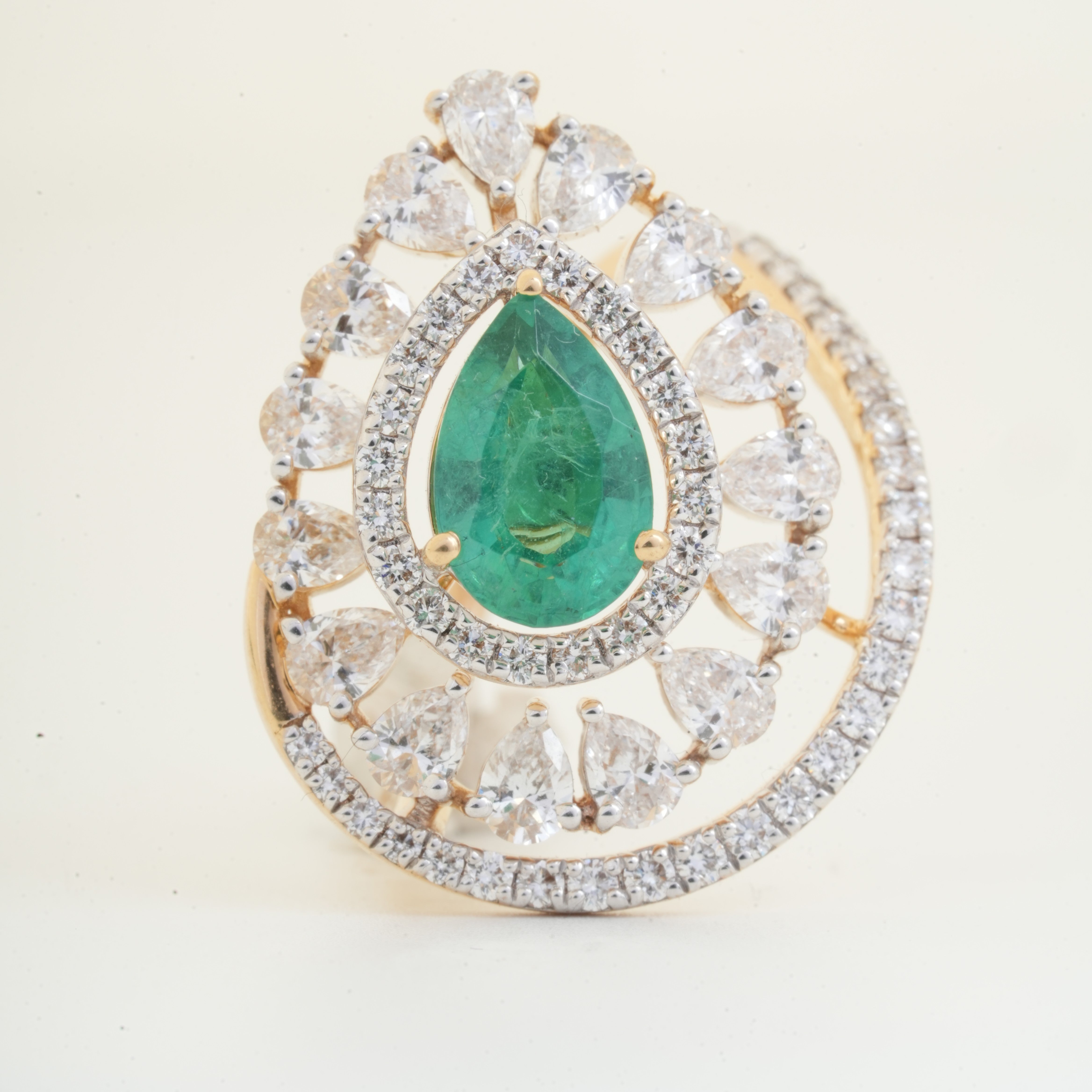 Pear cut emerald pendant with pear shape diamond halo and round diamond accents in gold by Glora Diamonds Chennai