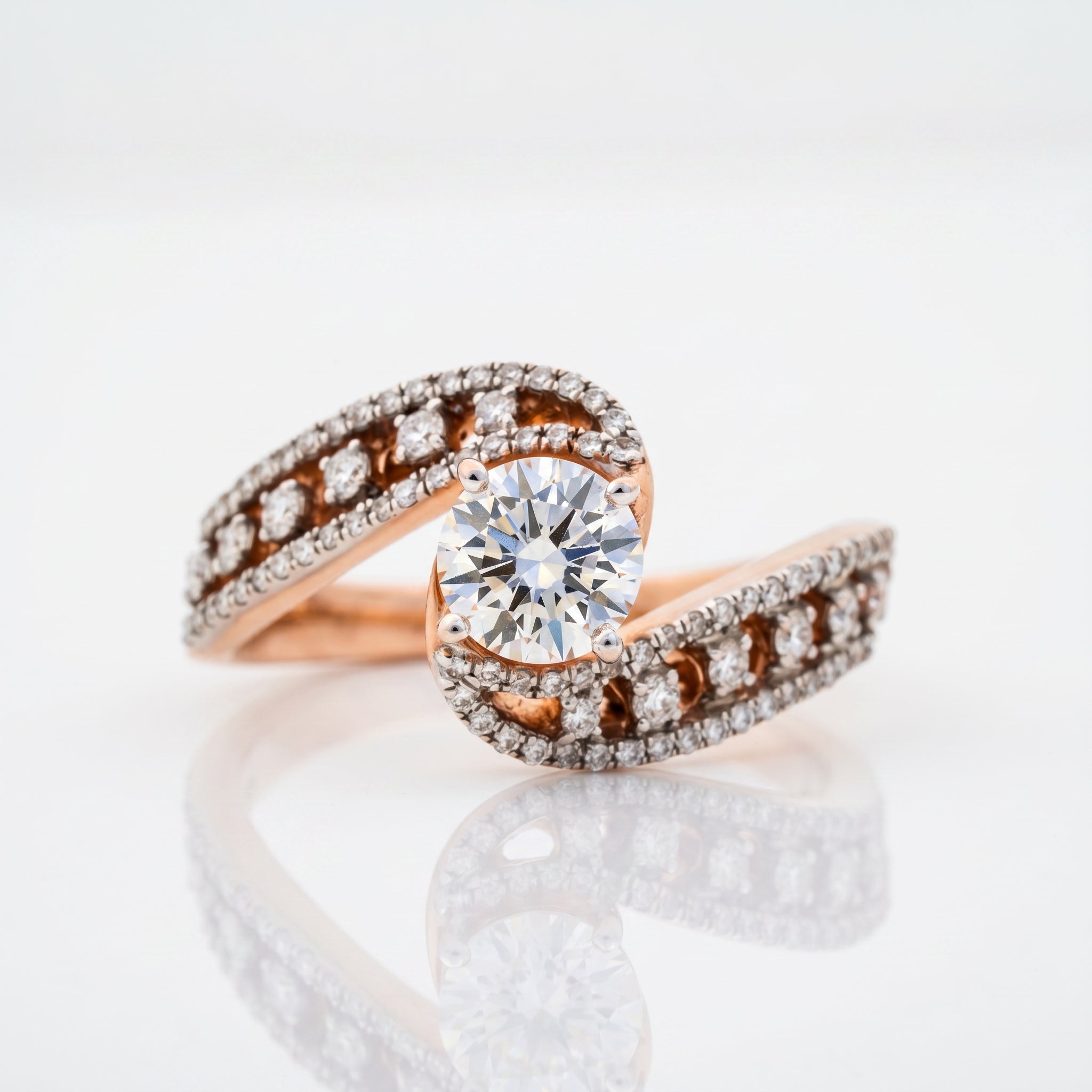 Round brilliant diamond infinity twist ring with pavé diamond bypass band in rose gold by Glora Diamonds Chennai