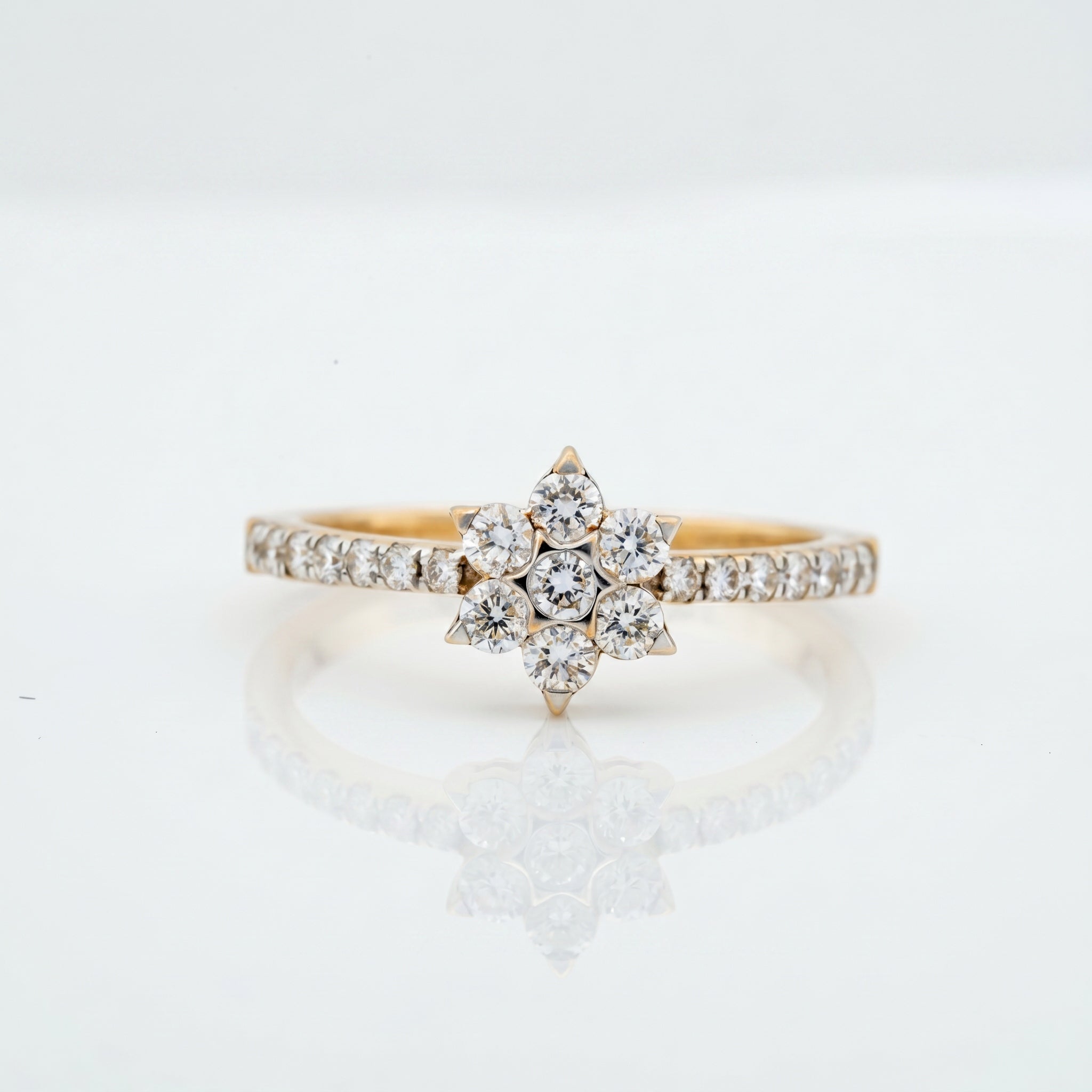 Round brilliant diamond starburst cluster ring with pavé diamond band in gold by Glora Diamonds Chennai