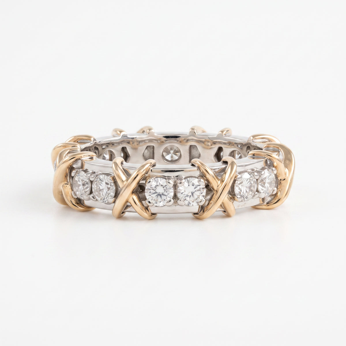 A two-tone diamond eternity ring featuring yellow gold twisted bands and a silver-toned band set with round diamonds, photographed on a clean white background.