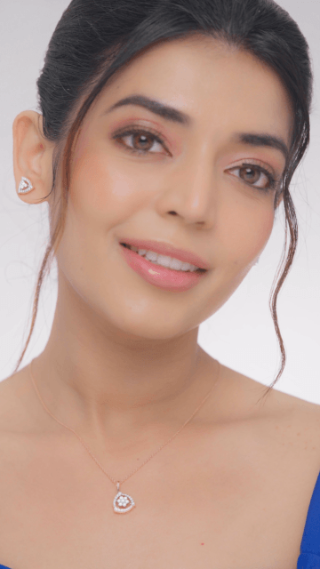 A woman wearing a diamond pendant necklace with a simple yet elegant design.