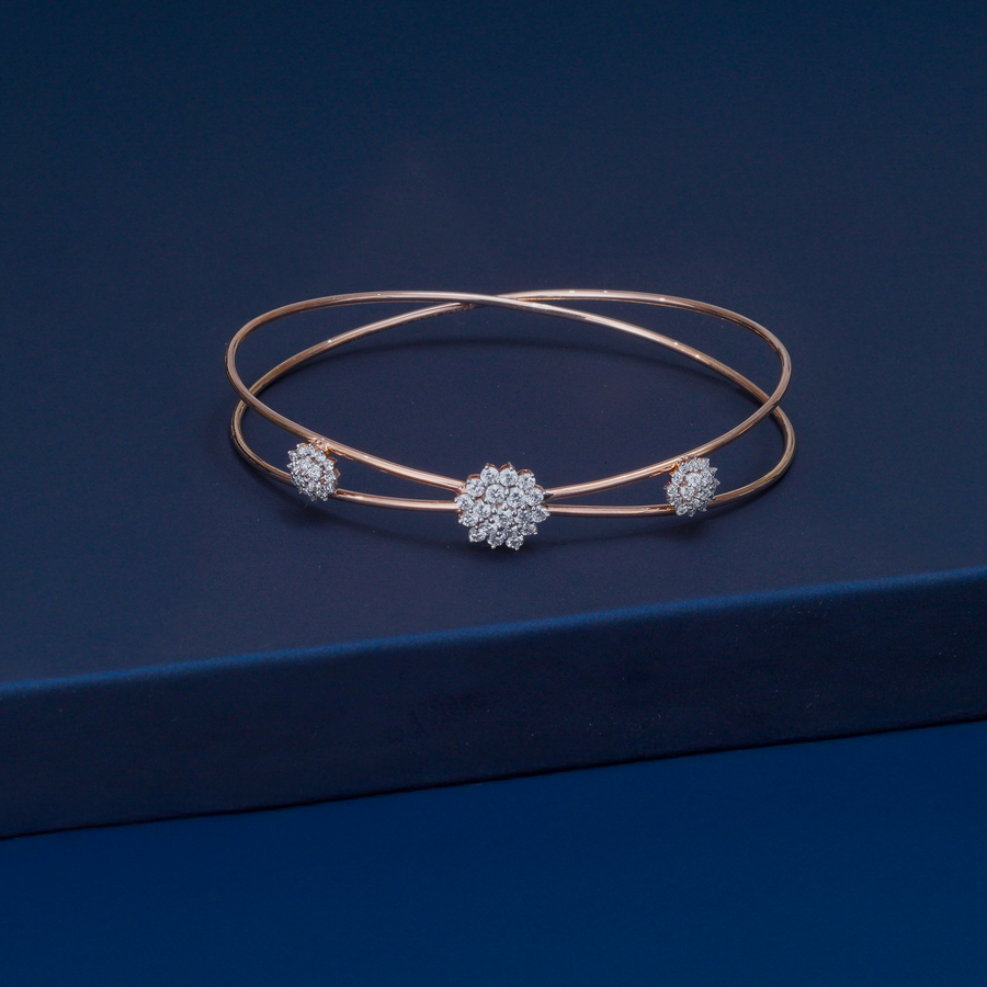Rose gold bracelet with diamond accents on a dark blue background