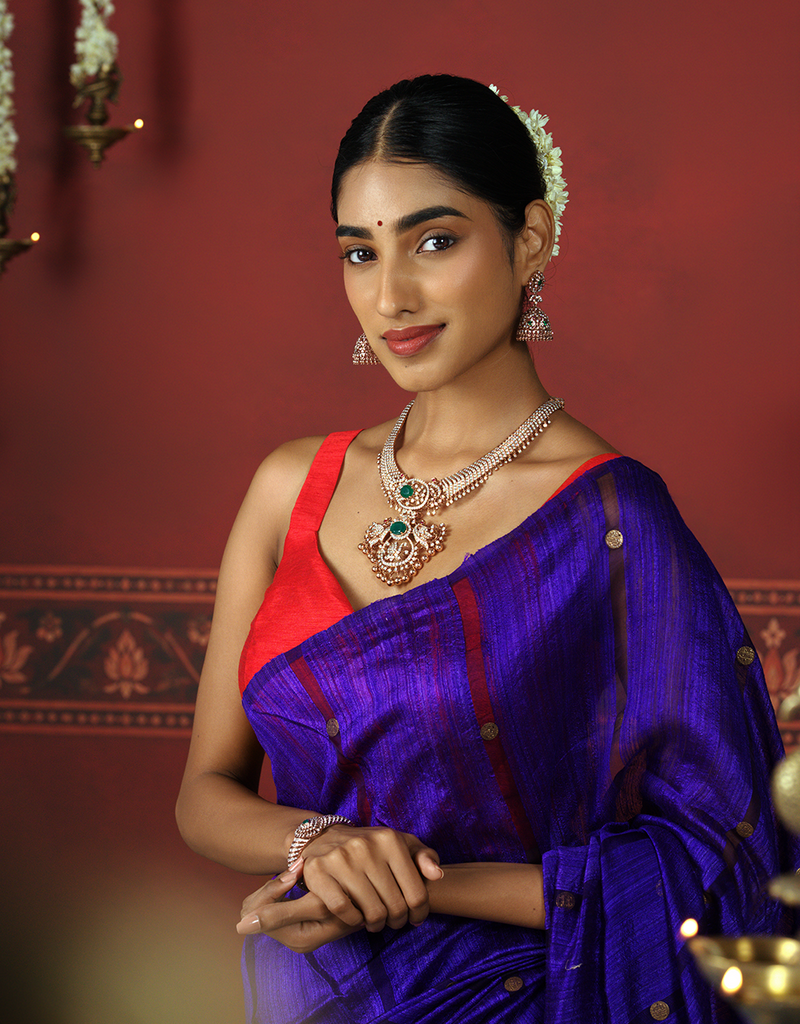 Model wearing jewellery with a purple sari