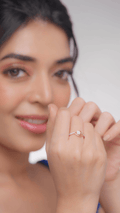 A woman showcasing a diamond ring on her finger, with the ring being the focus of the image.