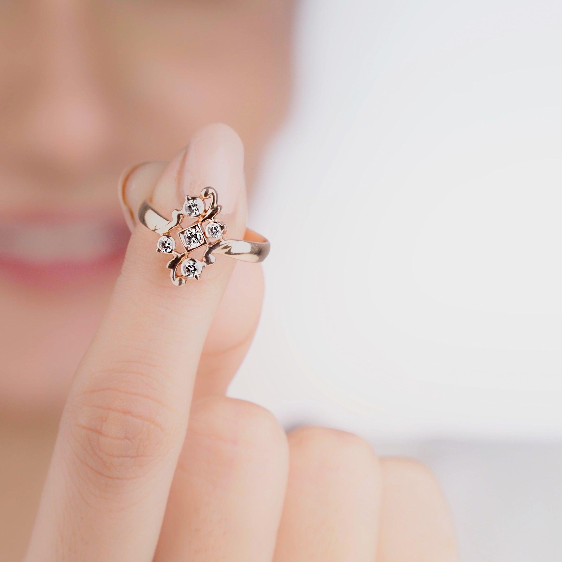 A close-up of a person's finger showcasing a gold diamond ring with multiple stones.