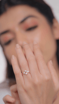 A person showcasing a diamond ring on their finger, with the ring being the focus of the image.