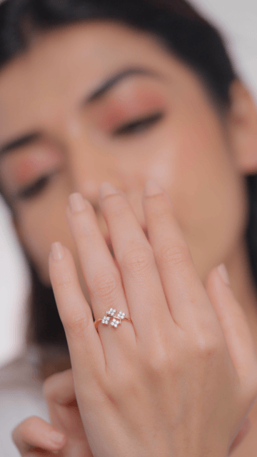 A person showcasing a diamond ring on their finger, with the ring being the focus of the image.
