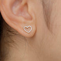 A close-up image of a person wearing a heart-shaped diamond earring.